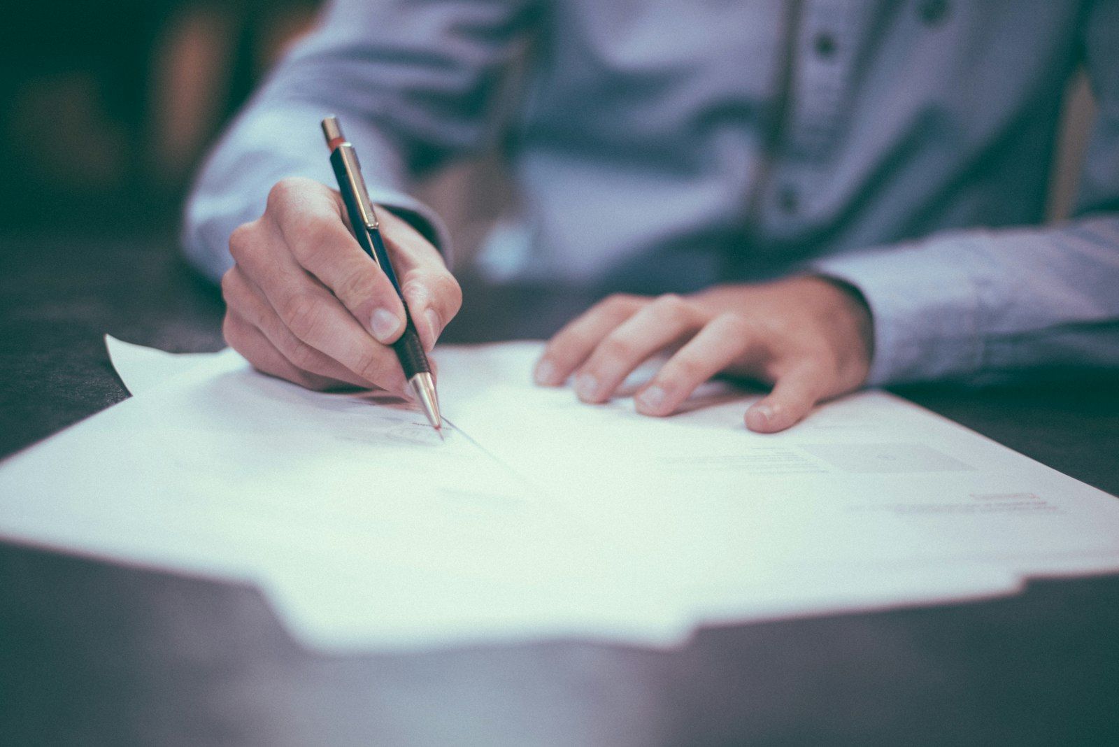 Firma de un documento oficial con sello sobre un escritorio de escribanía en Buenos Aires