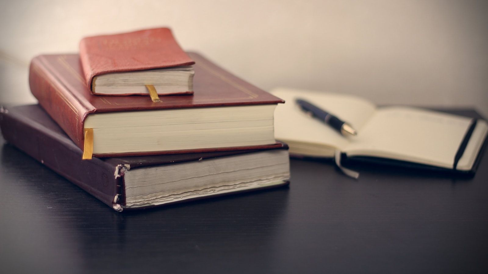 Códigos y libros jurídicos junto a una libreta de notas para traducción pública
